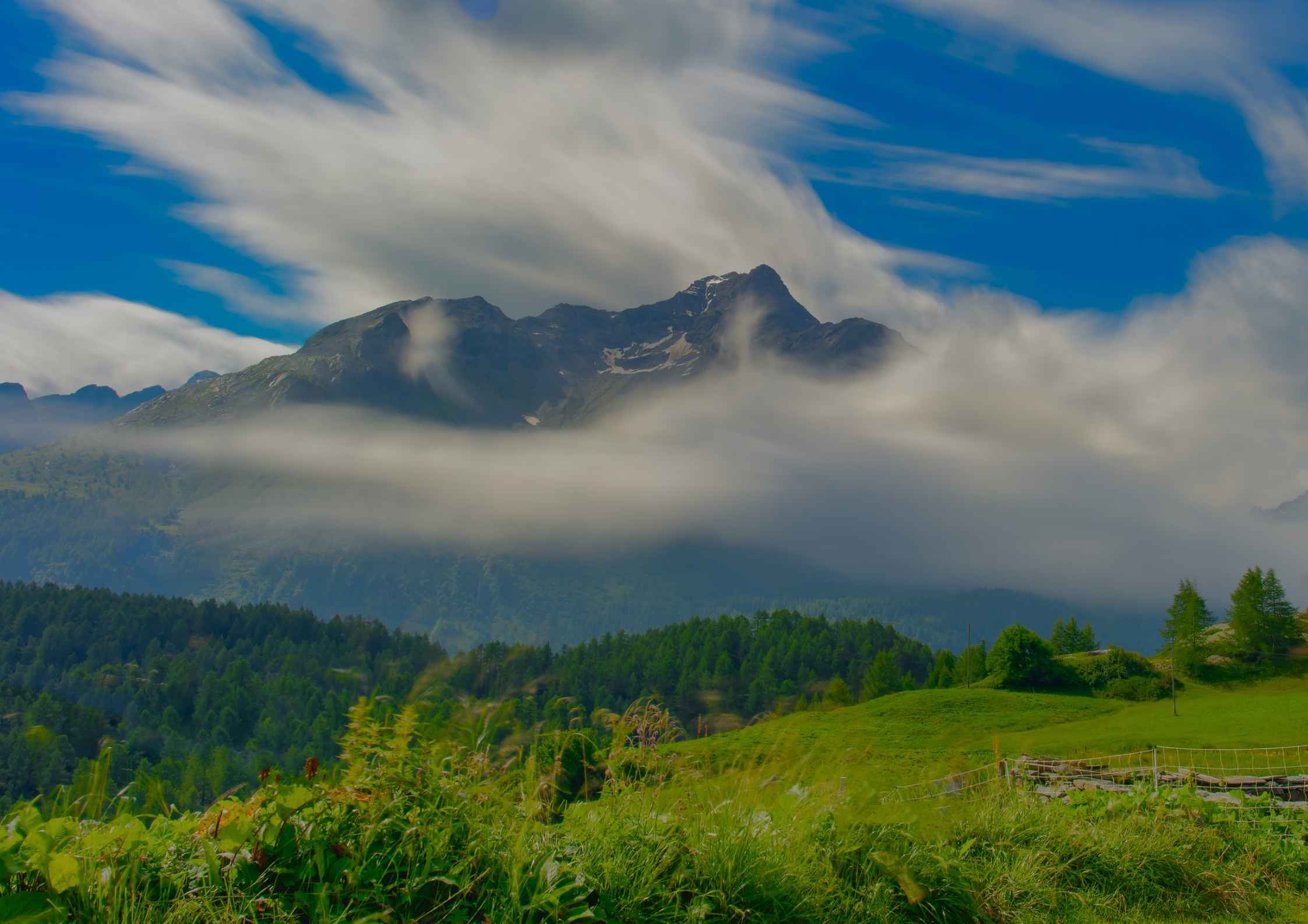 Large Landscape. With Blue skies, grey clouds, forest and woodlands, hills and mountains in the background