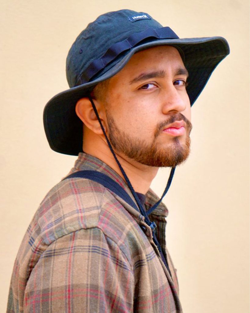 Serious male wearing a Hurley bucket hat and a checkered shirt