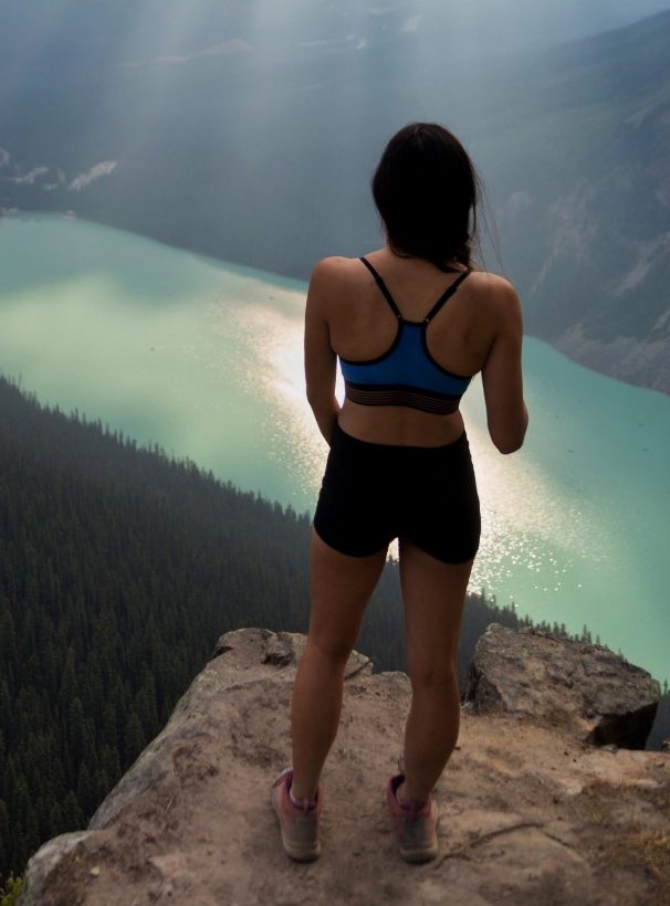 woman in yoga clothes looking at lake